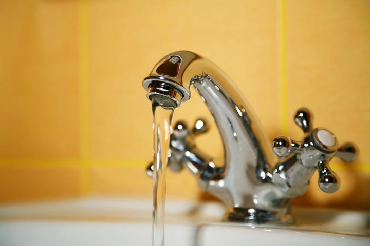 Image of a bathroom tap running water into a basin.