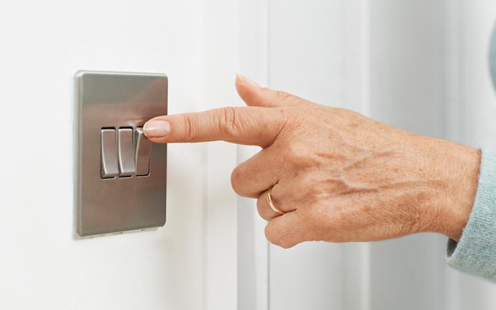 Photo of a woman's hand turning on light switch