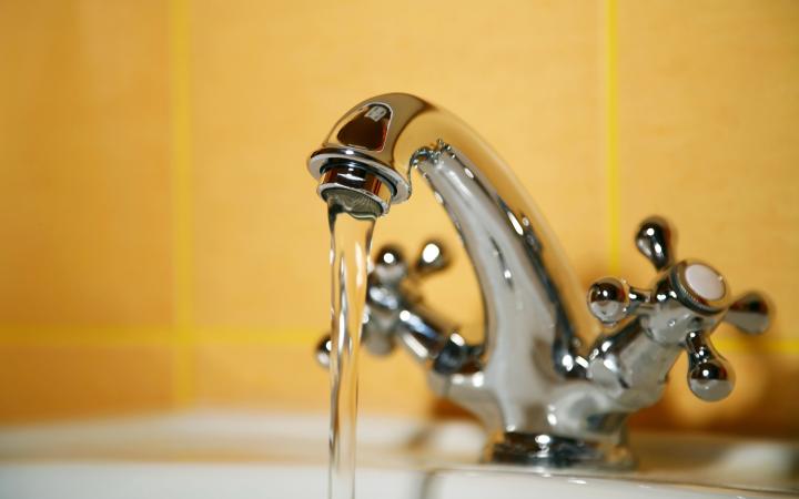 Image of a bathroom tap running water into a basin