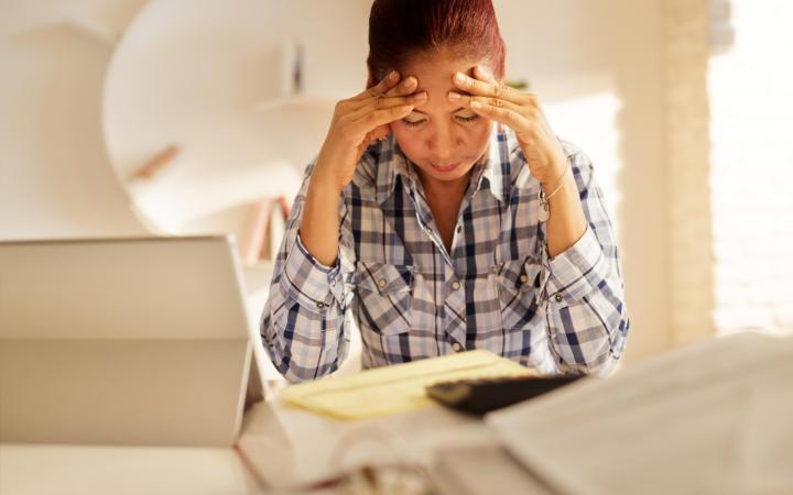 Women with head in hands looking at bills