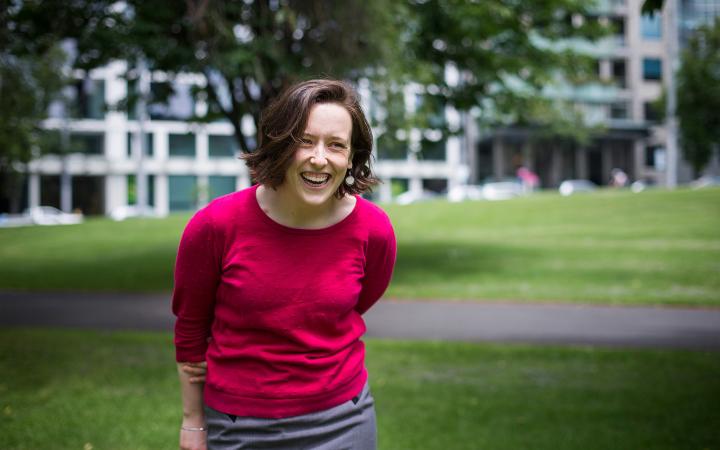 Siobhan, an Essential Services Commission employee, in a garden laughing at something that is off-camera.